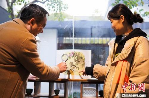 中国侨网孙德娜(右)和爱人欧阳奇共同讨论创作。 王昊阳 摄
