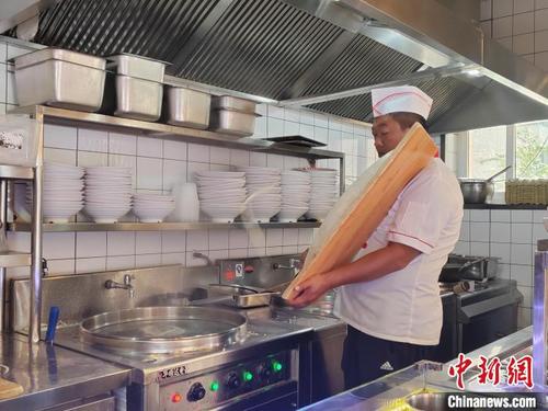 中国侨网赵老七飞刀削面制作技艺第五代传人赵喜平正在制作刀削面。 高雨晴 摄