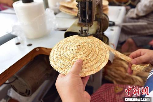 中国侨网图为青县一家草编工艺品生产企业内，麦草辫被缝制成圆形帽顶。　尹向平　摄
