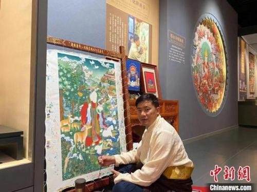 中国侨网图为更登才让和他的作品。（资料图）李玉峰摄