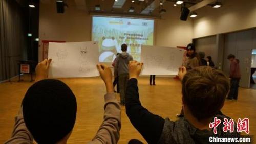 中国侨网图为德国学生高兴地举着三星堆线描图  柏林中国文化中心 供图