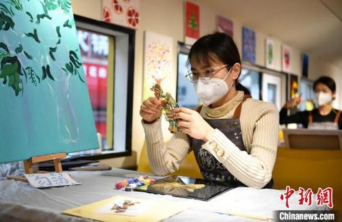 中国侨网图为12月9日,石家庄市裕华区一家文创非遗体验馆,市民体验制作传统手工皮影。 翟羽佳 摄