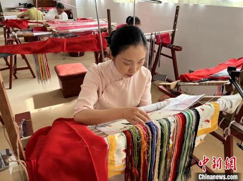 中国侨网图为陶卫华端坐在绣架前，正在制作一幅刺绣作品。　李韵涵　摄