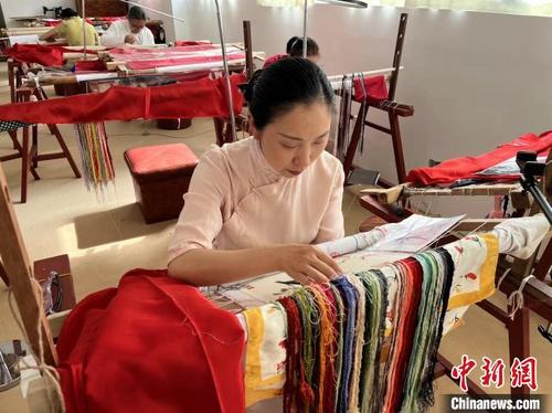 中国侨网图为陶卫华端坐在绣架前,正在制作一幅刺绣作品。 李韵涵 摄