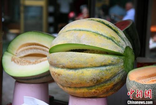 中国侨网7月,在熙熙攘攘的新疆喀什古城景区“汗巴扎”美食街上,几乎每个瓜果摊位上都摆放着“老汉瓜”。 中新社记者 孙亭文 摄